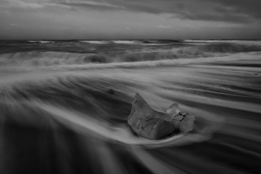 Monochrome picture of waves receding on Diamond Beach in Iceland