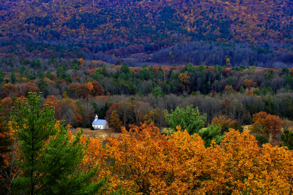 A white church sits nestled amongst the trees in Smokey Mountain National Park